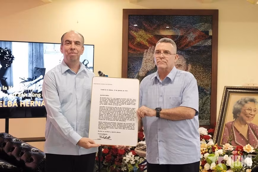 Manuel Enrique Montañé Enríquez, nieto de la heroína revolucionaria Melba Hernández, entrega al embajador Rogelio Polanco Fuentes una copia de la carta que el líder Fidel Castro le envió a Melba Hernández con motivo de su nombramiento como embajadora de Cuba en Vietnam. (Foto: qdnd.vn).