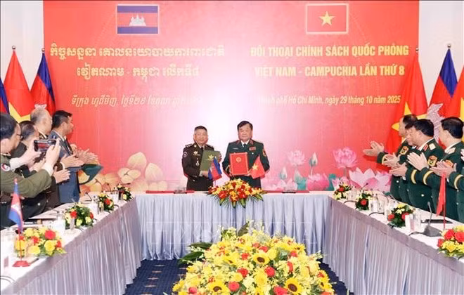 El teniente general Hoang Xuan Chien (derecha) y el general Chay Saingyun (izquierda) firman un memorando de entendimiento entre los Ministerios de Defensa de ambos países sobre cooperación en materia de derecho militar y de defensa, así como el acta del octavo Diálogo. (Foto: VNA)