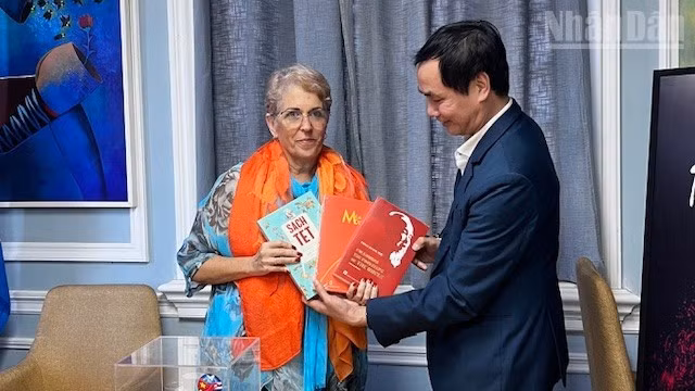 El poeta Huu Viet entrega libros a la presidenta de la Uneac, Marta Bonet.