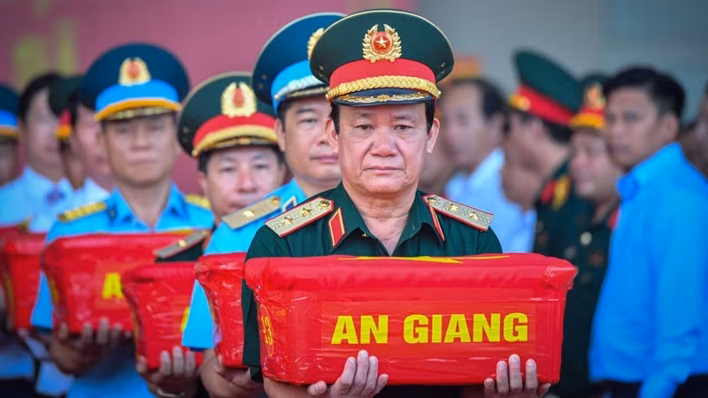 El general de división Ho Van Thai, comisario político de la Región Militar 9, carga una caja de muestras en el avión.