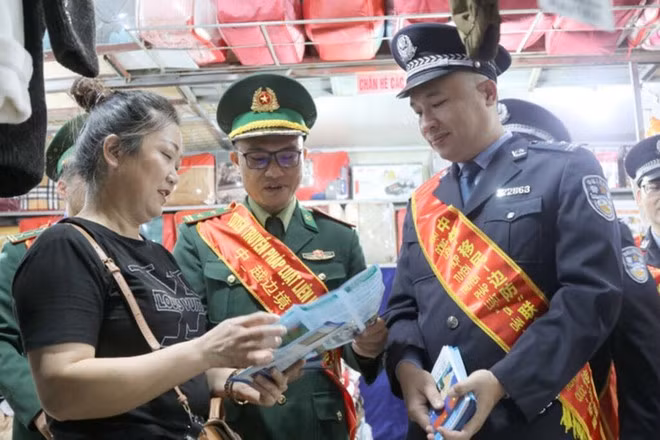 Las fuerzas fronterizas de Vietnam y China divulgan la legislación fronteriza entre los comerciantes en el mercado de Tan Thanh en Lang Son. (Foto: VNA)