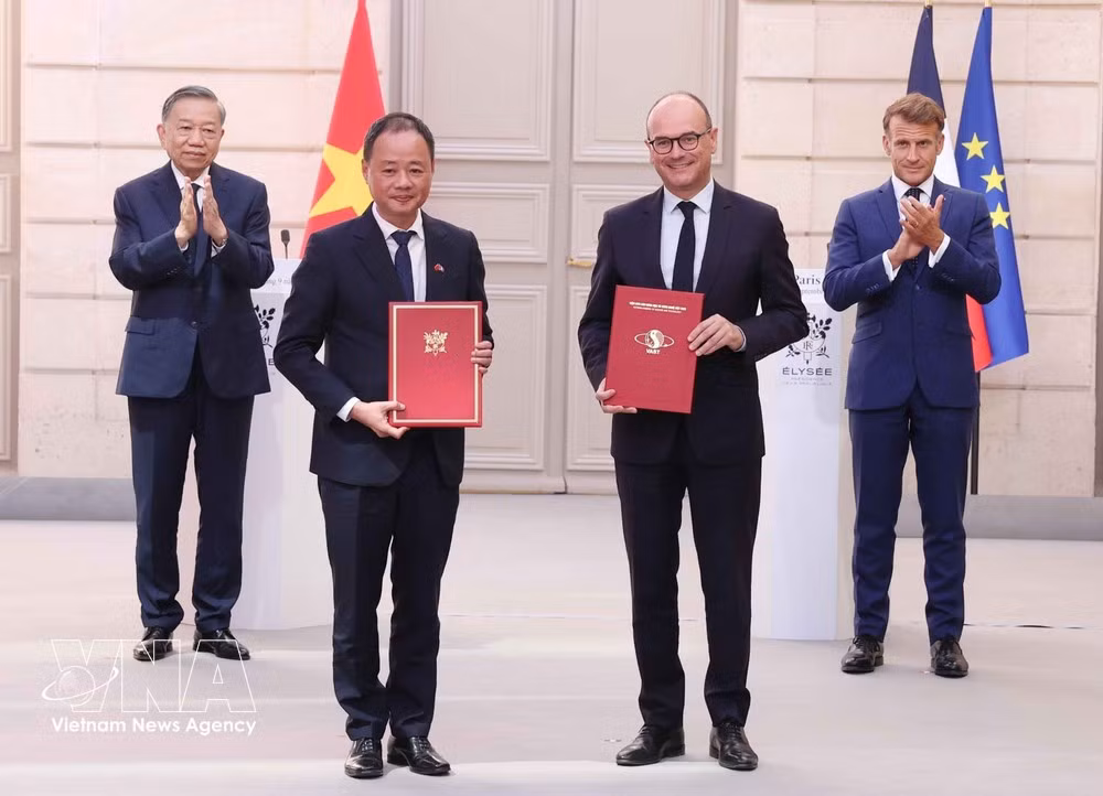 El secretario general del Partido Comunista y presidente de Vietnam, To Lam, y el presidente de Francia, Emmanuel Macron, presencian el intercambio de documentos de cooperación. (Foto: VNA)