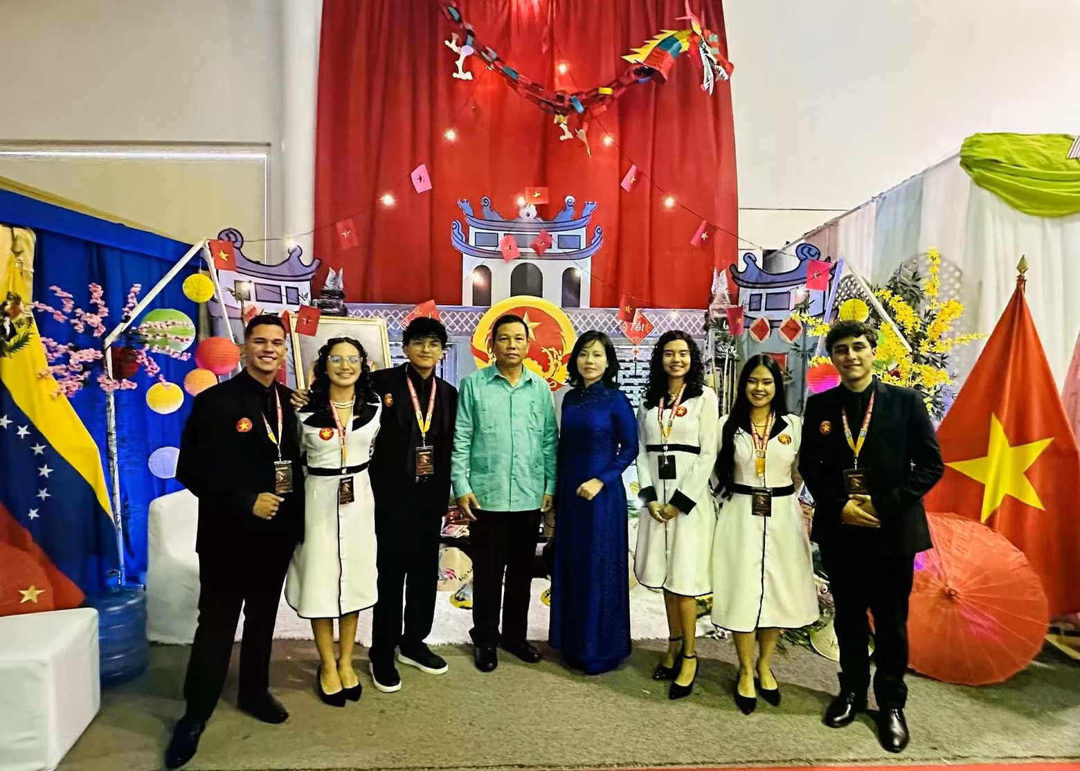 El embajador Vu Trung My (de camisa turquesa) y estudiantes que ayudan con la instalación del espacio “Vietnam: el país y la gente”. (Fotografía: baoquocte.vn)