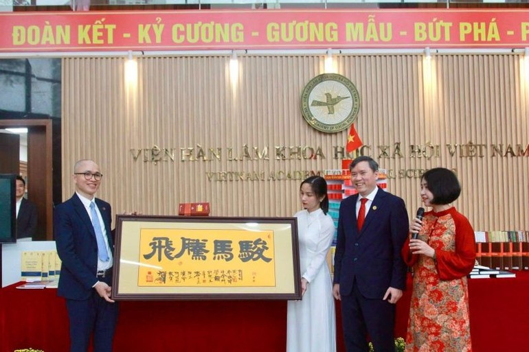 El presidente de la Academia de Ciencias Sociales de Vietnam, Le Van Loi, recibe una obra caligráfica del Instituto de Estudios Han-Nom en la ceremonia inaugural de la exposición.