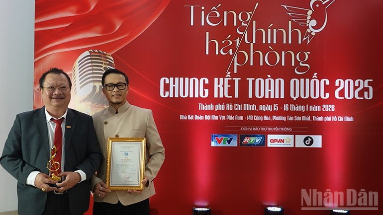 Luu Quoc Thang, subjefe de la Oficina de Representación del diario Nhan Dan en el sur (a la izquierda), y el director Dang Le Minh Tri en la ceremonia de premiación.
