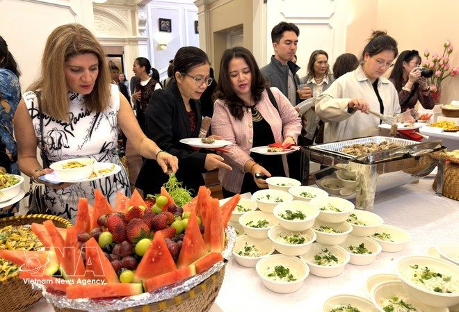 Los invitados disfrutan de platos vegetarianos vietnamitas en el evento. (Foto: VNA)