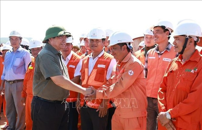 El primer ministro Pham Minh Chinh con ingenieros y trabajadores que construyen el proyecto de la línea de transmisión de 500 kV Lao Cai - Vinh Yen. (Foto: VNA) El primer ministro Pham Minh Chinh con ingenieros y trabajadores que construyen el proyecto de la línea de transmisión de 500 kV Lao Cai - Vinh Yen. (Foto: VNA)
