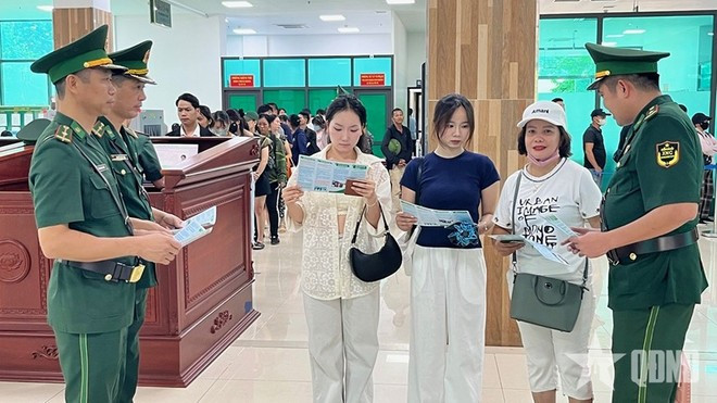 Oficiales vietnamitas distribuyen folletos a los pasajeros que cruzan por la puerta fronteriza. (Foto: qdnd.vn) Oficiales vietnamitas distribuyen folletos a los pasajeros que cruzan por la puerta fronteriza. (Foto: qdnd.vn)