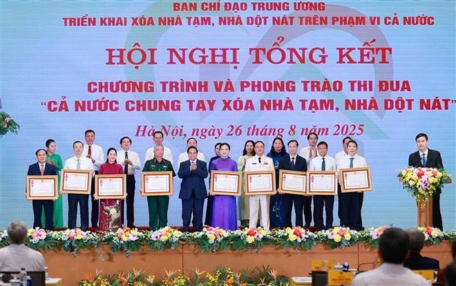 El primer ministro Pham Minh Chinh entrega la Orden del Trabajo de tercera clase a colectivos con logros destacados en el programa "Todo el país se une para eliminar viviendas precarias" (Foto: VNA) El primer ministro Pham Minh Chinh entrega la Orden del Trabajo de tercera clase a colectivos con logros destacados en el programa "Todo el país se une para eliminar viviendas precarias" (Foto: VNA)