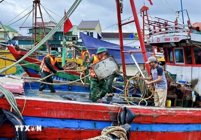 Oficiales y soldados de la estación de guardia fronteriza de Dien Thanh en la provincia de Nghe An despliegan fuerzas para apoyar a los pescadores en el traslado de sus embarcaciones a los refugios. (Foto: VNA) Oficiales y soldados de la estación de guardia fronteriza de Dien Thanh en la provincia de Nghe An despliegan fuerzas para apoyar a los pescadores en el traslado de sus embarcaciones a los refugios. (Foto: VNA)