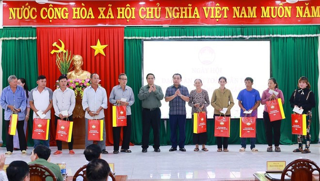 El primer ministro Pham Minh Chinh entrega obsequios a las familias beneficiarias de políticas sociales en la comuna de De Gi (Foto: VNA)