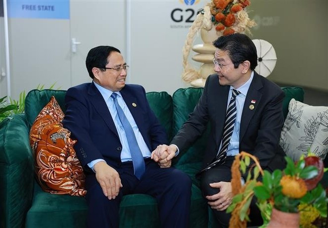 El primer ministro de Vietnam, Pham Minh Chinh, y el primer ministro de Singapur, Lawrence Wong. (Foto: VNA)