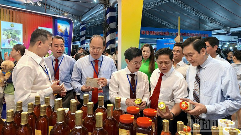 El secretario del Comité Provincial del Partido de Ca Mau, Nguyen Ho Hai (tercero por la izquierda), visita el puesto donde se exhiben productos OCOP en el marco de la Fiesta.