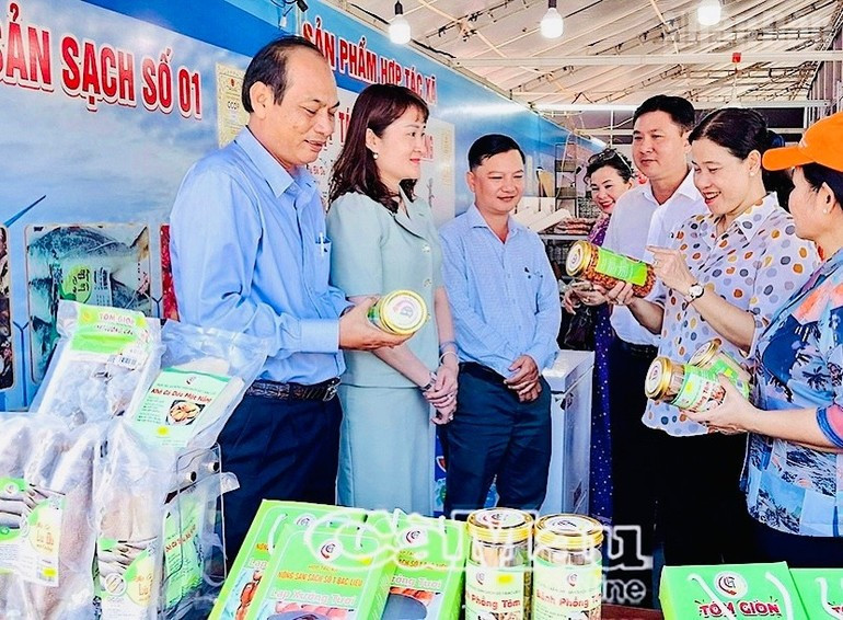 To Viet Thu, miembro permanente del Comité del Partido y secretario del barrio de Bac Lieu (segundo a la derecha), visita el pabellón de productos OCOP de la localidad.