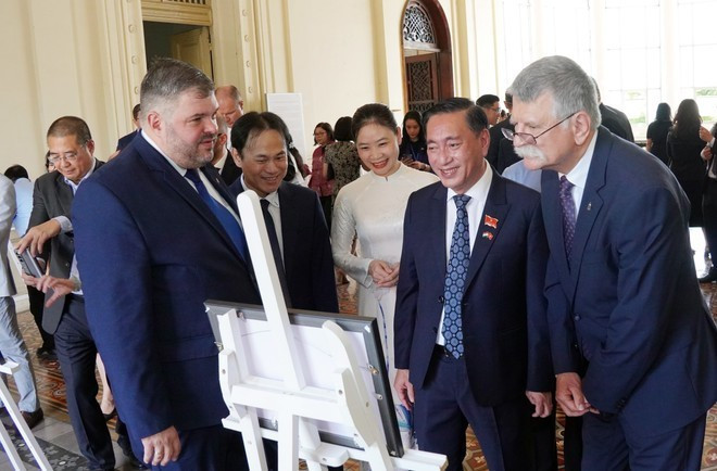 El presidente de la Asamblea Nacional Húngara, Kover Laszlo (primero, desde la derecha), y los delegados visitan la exposición fotográfica. (Foto: VNA) El presidente de la Asamblea Nacional Húngara, Kover Laszlo (primero, desde la derecha), y los delegados visitan la exposición fotográfica. (Foto: VNA)