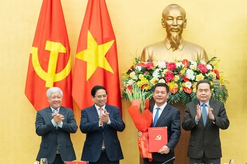 El primer ministro Pham Minh Chinh (segundo desde la izquierda) y el presidente de la Asamblea Nacional Tran Thanh Man (extrema derecha), entregan la decisión del nombramiento y ofrecen flores a Nguyen Hong Dien. (Foto: Nhan Dan)
