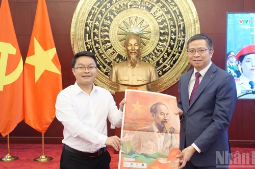 El representante de la corresponsalía del periódico Nhan Dan en China entrega el suplemento especial al embajador de Vietnam en Pekín, Pham Thanh Binh.