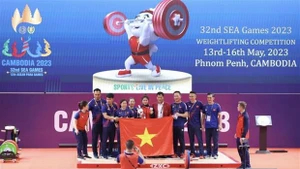 La halterófila Dinh Thi Thu Uyen (medio) celebra su victoria (Fotografía: VNA)