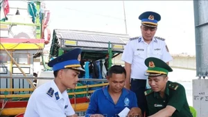 Las autoridades pertinentes movilizan a los pescadores a firmar un compromiso para combatir la pesca ilegal en el puerto pesquero de Cua Viet. (Foto: VNA)