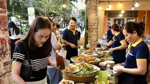 Los visitantes degustan los platos en el festival. (Foto: VNA)
