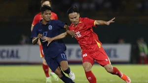 Un jugador vietnamita (con camiseta roja) disputa por el balón. (Fotografía: Nhan Dan)