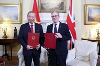 El secretario general del Partido Comunista de Vietnam, To Lam, y el primer ministro del Reino Unido, Keir Starmer, intercambian una declaración conjunta sobre la elevación de los nexos bilaterales a una Asociación Estratégica Integral. (Foto: VNA)