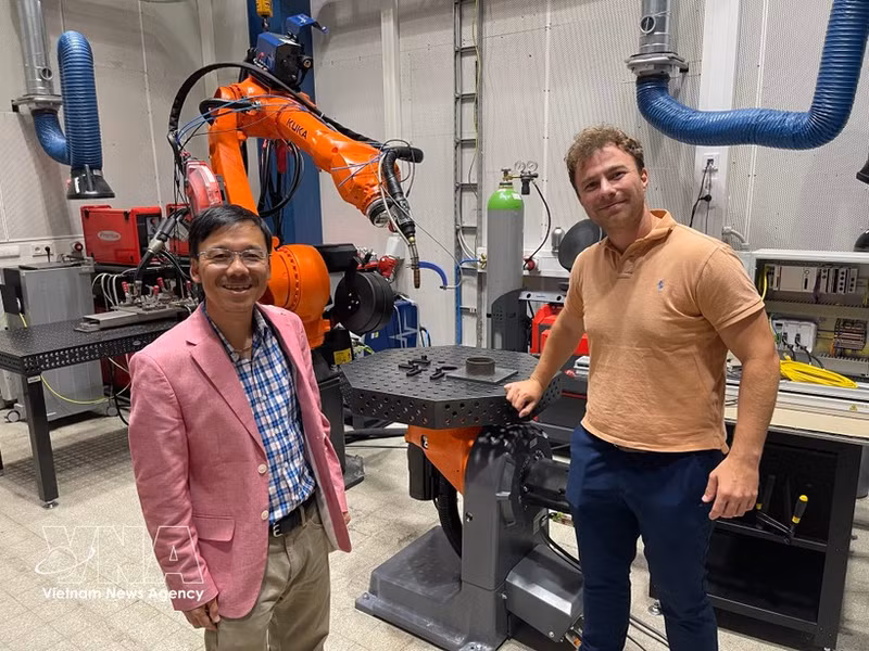 El profesor asociado Vu Viet Hung (izquierda) visita un espacio de impresión 3D que cuenta con sistemas robóticos. (Foto: VNA)
