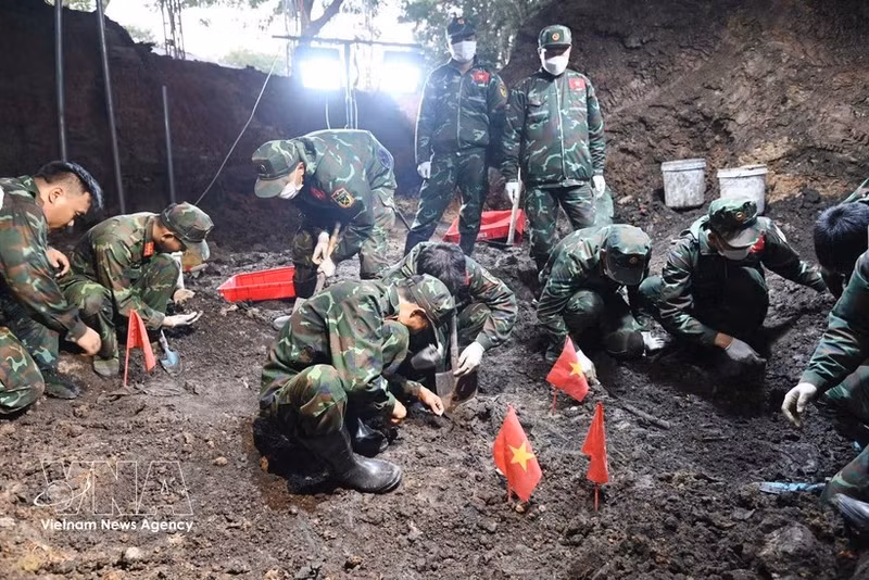 Oficiales y soldados del Equipo K74 realizan la búsqueda y recuperación de los restos de los soldados caídos en la fosa común recientemente descubierta. (Foto: VNA)