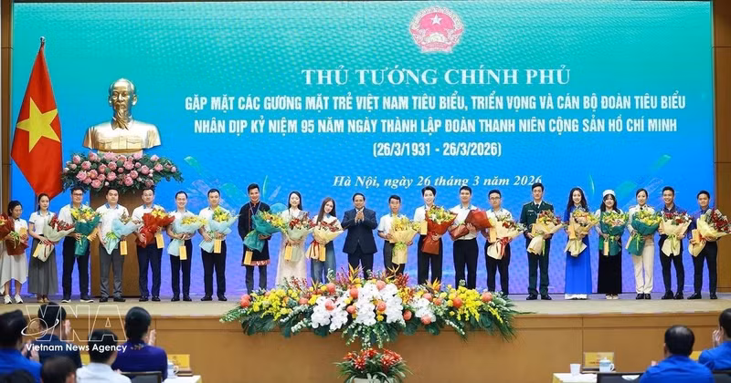 El primer ministro Pham Minh Chinh entrega flores para felicitar a los jóvenes vietnamitas destacados. (Foto: VNA)