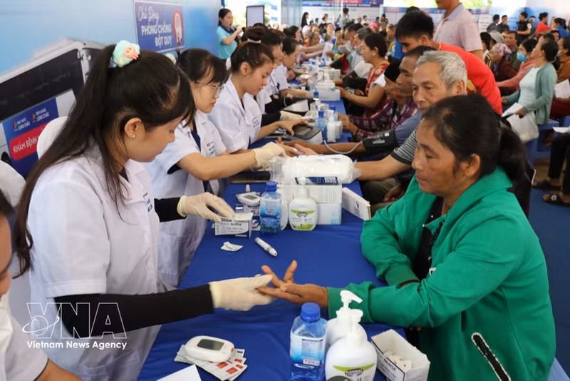 Los residentes del barrio de Dong Gia Nghia participan en revisiones médicas durante un programa gratuito de detección de enfermedades. (Foto: VNA)