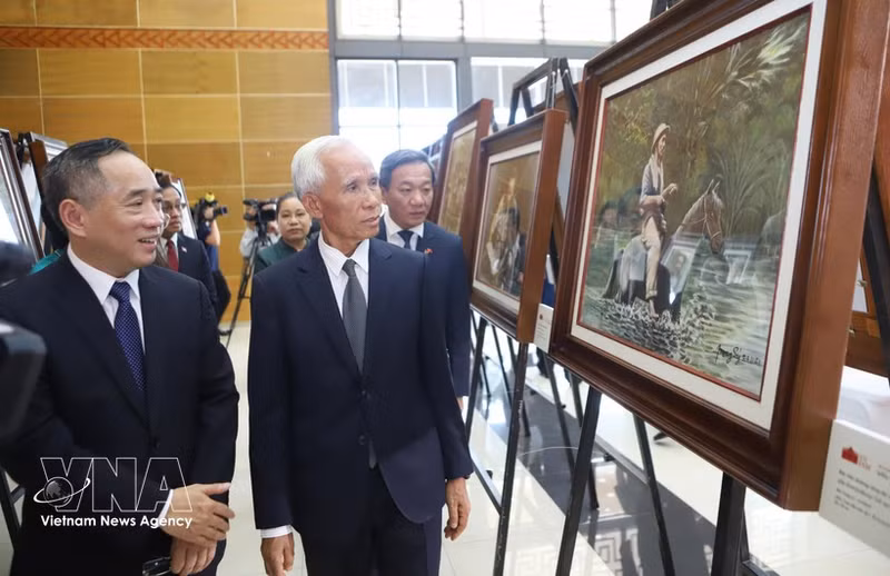 Khamphan Pheuiyavong, jefe del Departamento Central de Propaganda de Laos, y otros delegados visitan la exposición. (Foto: VNA)