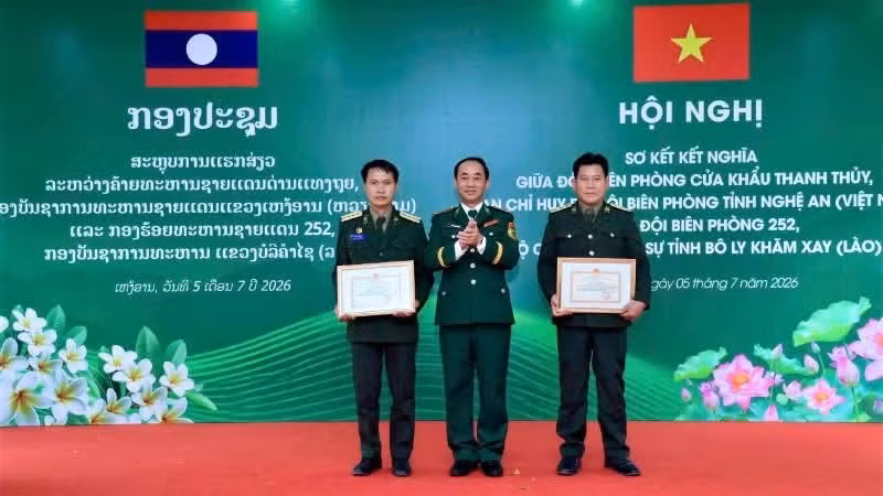 El coronel Tran Quang Trung, comisario político de la Guardia Fronteriza de Nghe An, entrega certificados de reconocimiento a un colectivo y a una persona de la Compañía de Guardia Fronteriza 252 por sus destacados logros en la ejecución del Programa de Hermanamiento.
