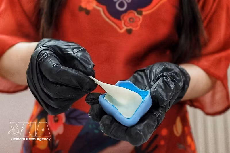 Cada pétalo se moldea con masa de To he, se aplana y se le da forma manualmente antes de ensamblarlo para crear la flor. Esta técnica permite conseguir curvas, finura y contornos naturales. (Foto: VNA)