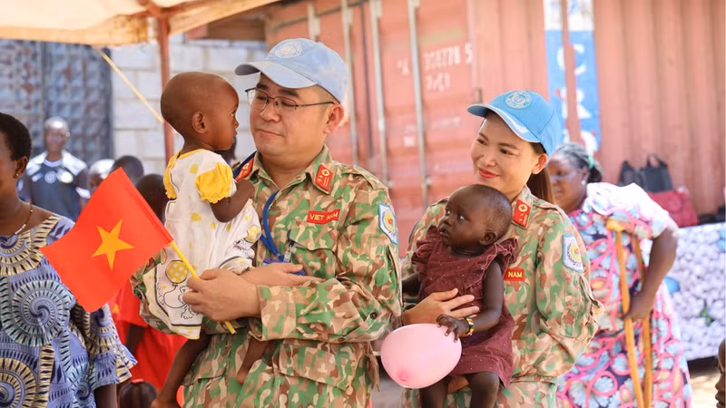 Miembros del Hospital de Campaña de Nivel 2 número 7 de Vietnam sostienen en brazos a niños del hogar St. Clare, en Juba, capital de Sudán del Sur. (Foto: Tien Phuc)