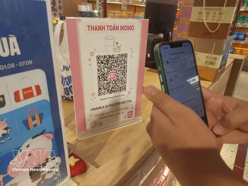 Un cliente realiza un pago mediante código QR. (Foto: VNA)