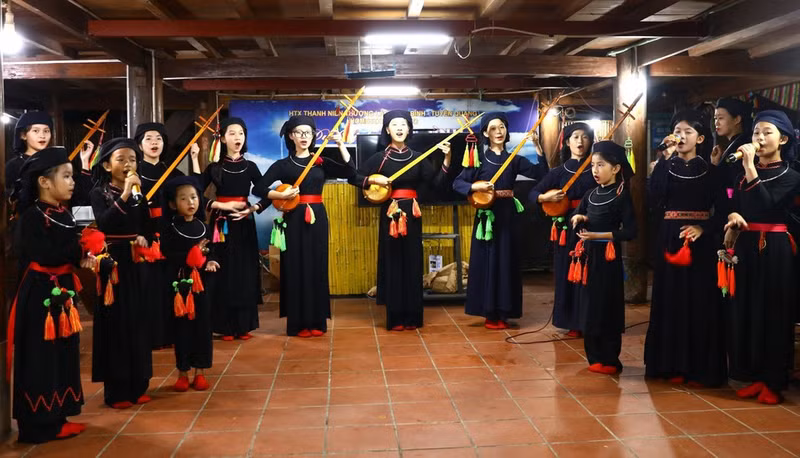 Presentación de cantos Then con laúd Tinh para visitantes en la casa de familia Tai Ngao, aldea de Na Tong, comuna de Thuong Lam. (Foto: VNA)
