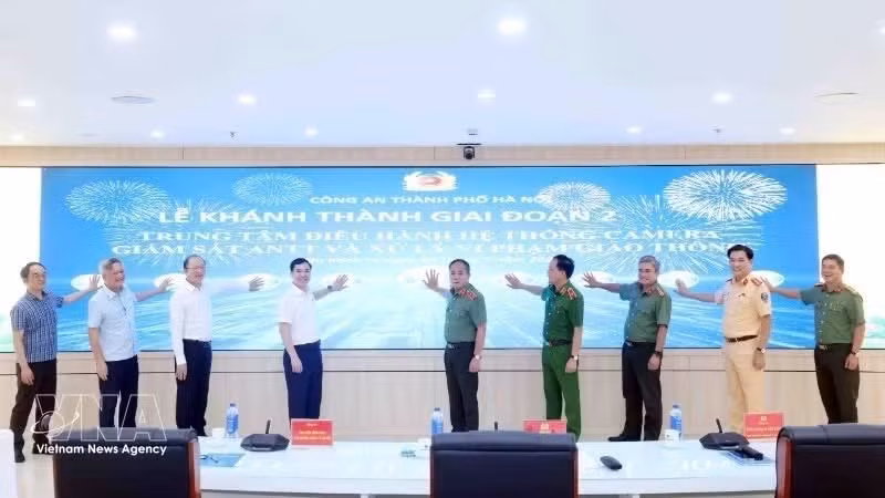 Los delegados pulsan el botón para inaugurar el proyecto de modernización del Centro de Información de Mando y la instalación de un sistema de cámaras de vigilancia. (Foto: VNA)