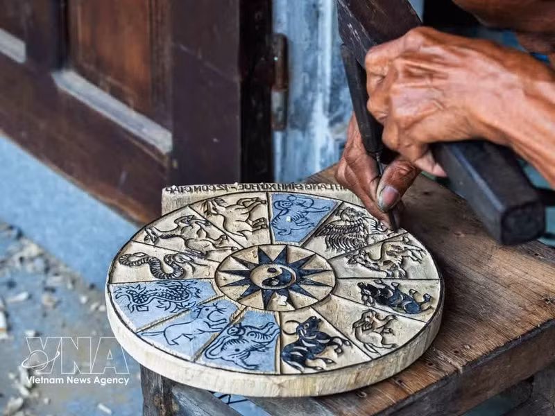 El grabado en madera no solo requiere fuerza en las manos y perseverancia, sino también memoria y capacidad de visualización; el artesano debe tallar de manera completamente invertida respecto a la imagen final, ya que todos los trazos y motivos se realizan en sentido contrario. (Foto: VNA)