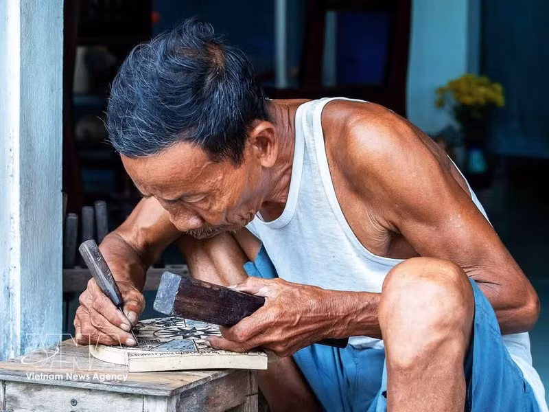 El artesano Ky Huu Phuoc (77 años) es el heredero de la novena generación de la familia dedicada a la pintura del pueblo de Sinh. (Foto: VNA)