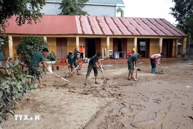 Oficiales y soldados del Batallón 6, Regimiento 12, División 3, de la Región Militar 1, ayudan a la escuela secundaria de la comuna de Yen Binh, en la provincia de Lang Son, a limpiar las aulas y el recinto escolar. (Foto: VNA)