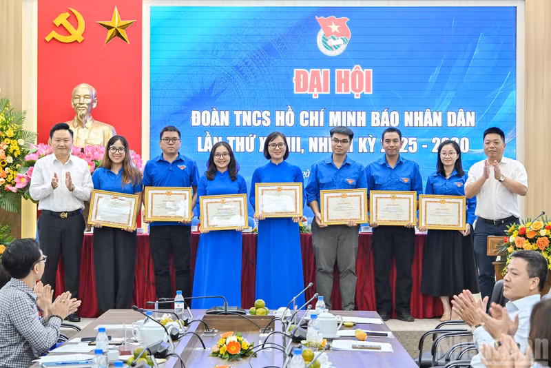 Que Dinh Nguyen y Phan Van Hung, ambos redactores subjefes del periódico Nhan Dan, entregan el certificado de mérito del presidente-editor del diario al Comité de la UJCHCM en el periódico Nhan Dan del XXVIII mandato.