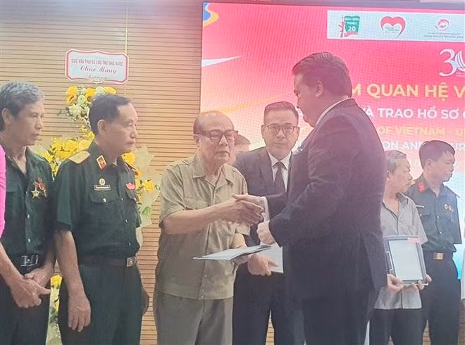 El embajador de Estados Unidos en Vietnam, Marc Knapper, entrega objetos de guerra a los veteranos. (Foto:VNA)