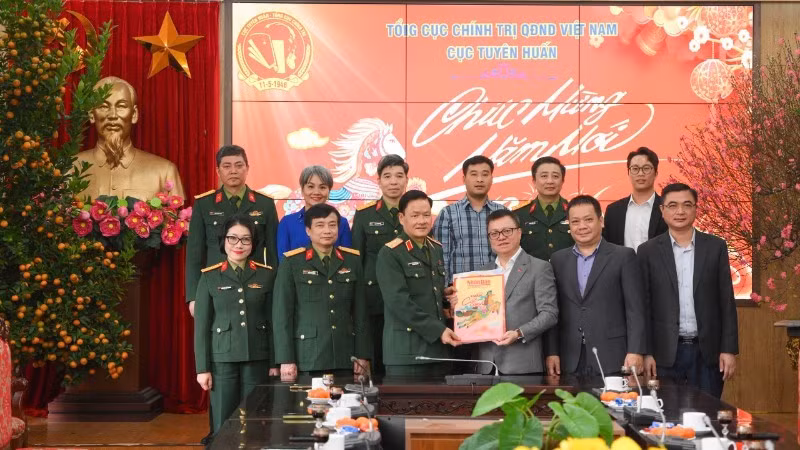 Le Quoc Minh, presidente-editor de Nhan Dan, entrega publicaciones del Tet de Nhan Dan a oficiales y soldados del Departamento de Propaganda y Educación, del Departamento General de Política del Ejército Popular de Vietnam.