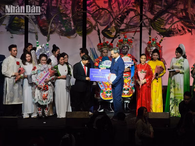 Do Phuoc Trung, subdirector del Servicio de Cultura y Deportes de Ciudad Ho Chi Minh, entrega a Vuong Huu Nhan una colección de libros en lengua vietnamita, como estímulo para los esfuerzos de la UGVF por preservar el idioma y la cultura entre las generaciones jóvenes de vietnamitas en Francia.