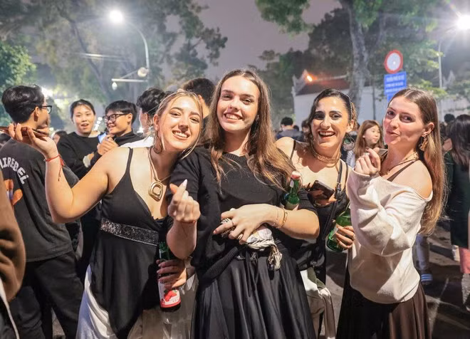 Extranjeros disfrutan la vibrante llegada de 2026 en la capital vietnamita. (Foto: VNA)