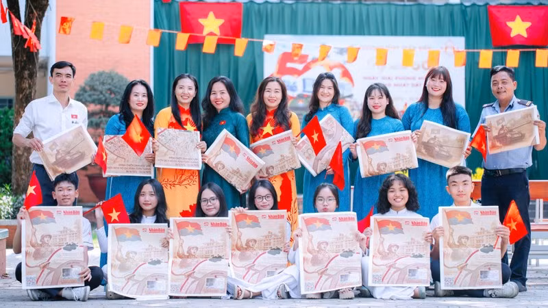Docentes y estudiantes en Dong Nai con el suplemento especial del periódico Nhan Dan.