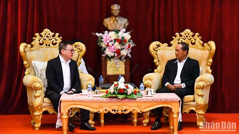 El secretario del Partido y gobernador de Luang Prabang, Khamkhan Chanthavisuk, recibe a Le Quoc Minh, presidente-editor del periódico Nhan Dan.