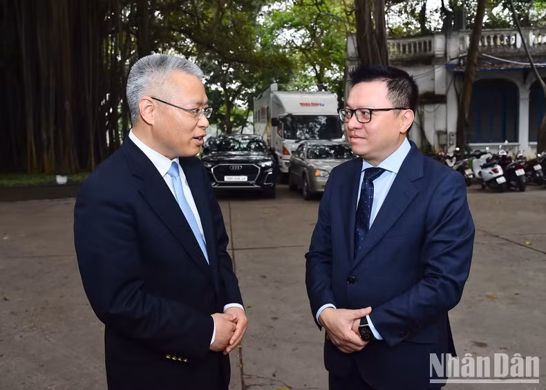 Quoc Minh y Hu Zhaoming conversan después de la reunión.