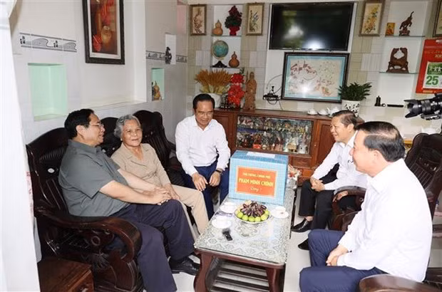 El primer ministro Pham Minh Chinh realiza una visita para entregar obsequios a Pham Thi Xinh, inválida de guerra en el distrito de Ben Luc.