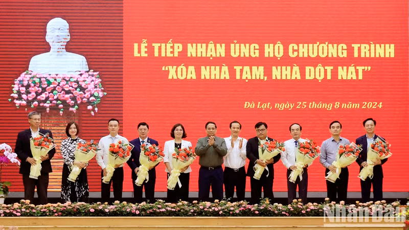 Minh Chinh y el secretario interino del Comité del Partido en Lam Dong, Nguyen Thai Hoc, entregan flores para agradecer a los patrocinadores.